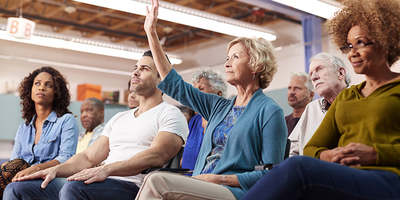 Woman Asking Question At Neighborhood Meeting In Community Center | hoa board meetings