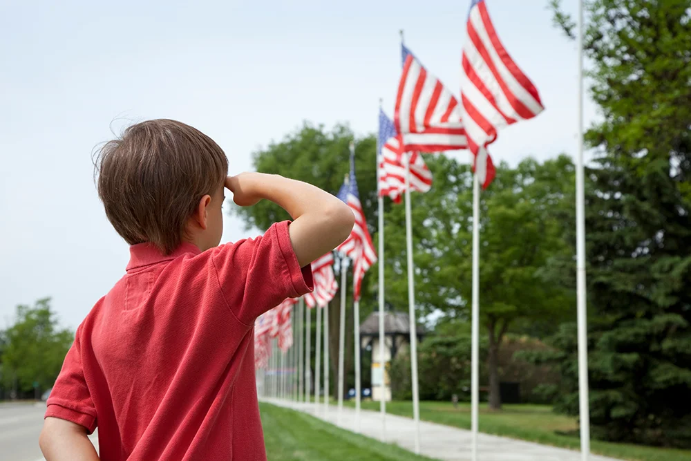 kid saluting usa flag | memorial day flag etiquette