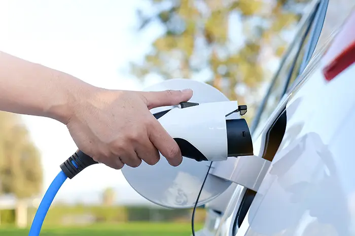 holding a car charger | ev charging station in HOA